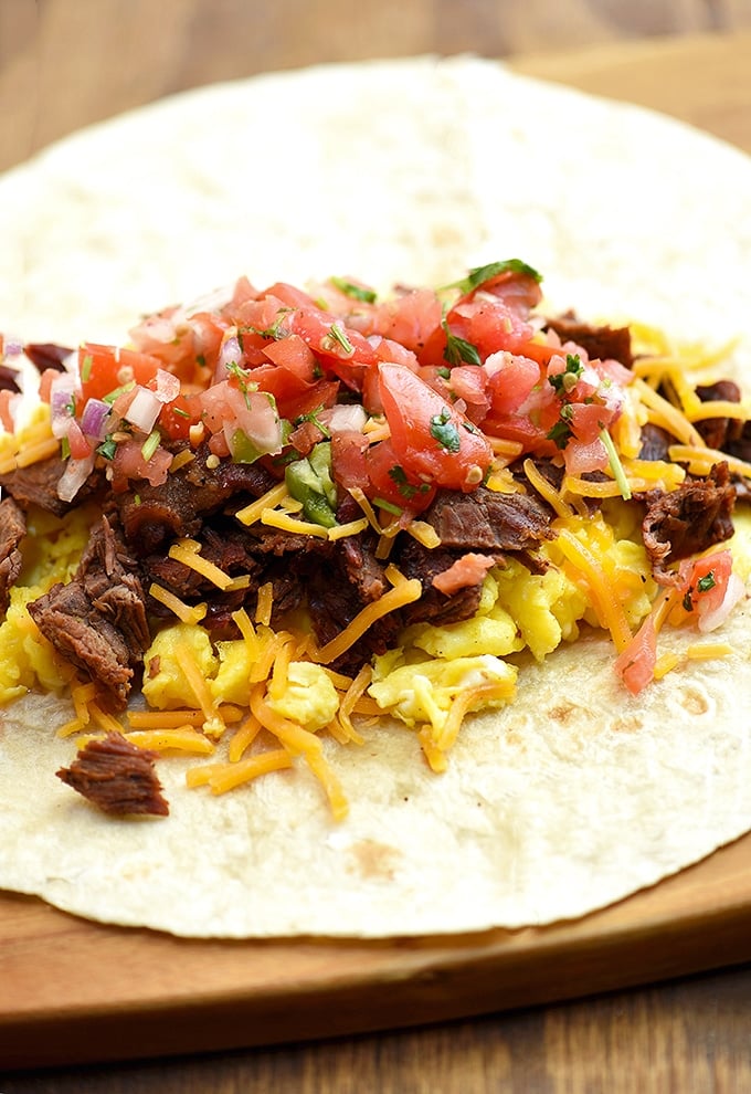 warm large flour tortilla topped with chopped carne asada, scrambled eggs, pico de gallo, and cheddar cheese to make into steak and egg burrito