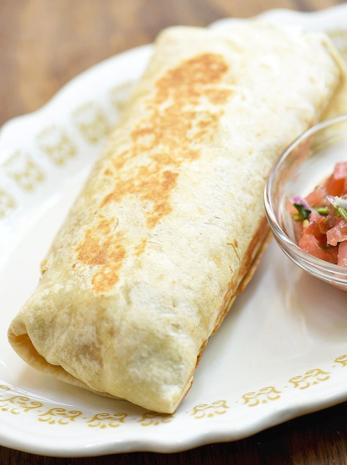 steak and egg breakfast burrito with a side of salsa