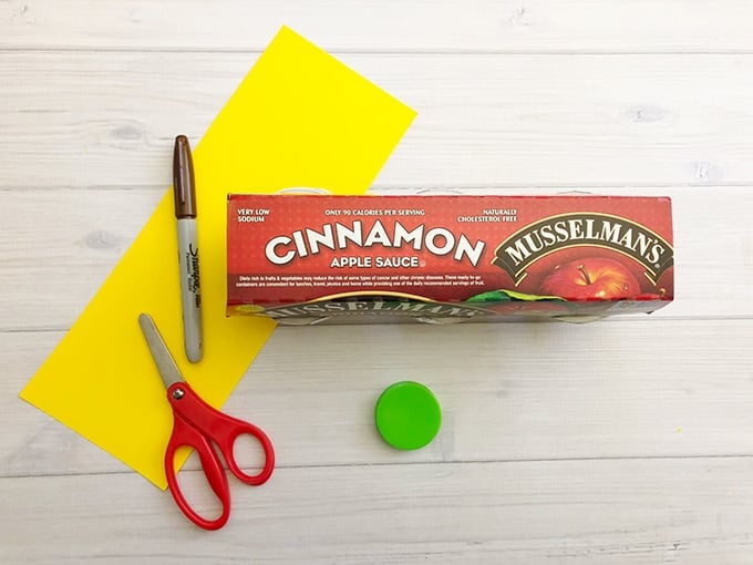 yellow cardstock paper, glue, marker and applesauce cups to make Winnie the Pooh snack cup toppers