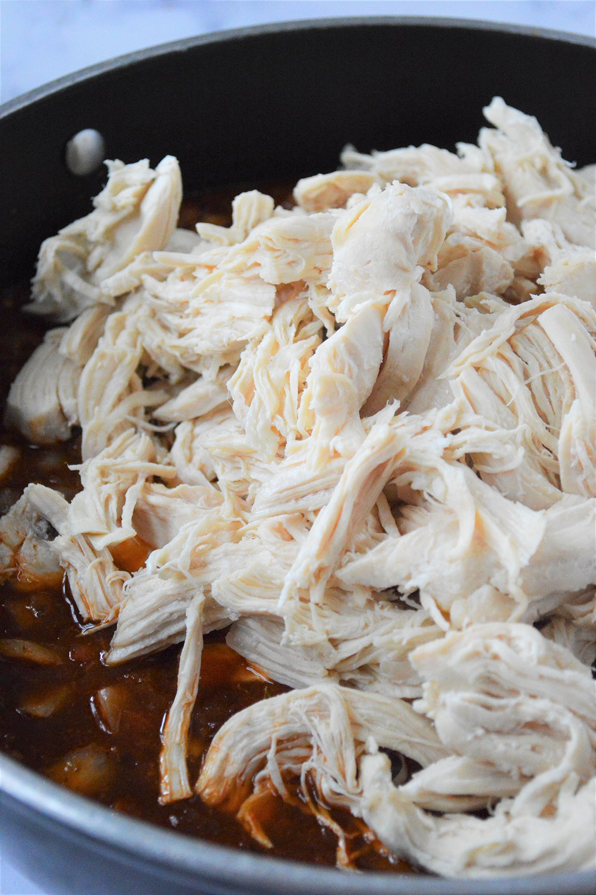 shredded chicken in spicy chipotle sauce in a skillet