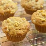 Banana Nut Muffins with walnuts on a wire rack