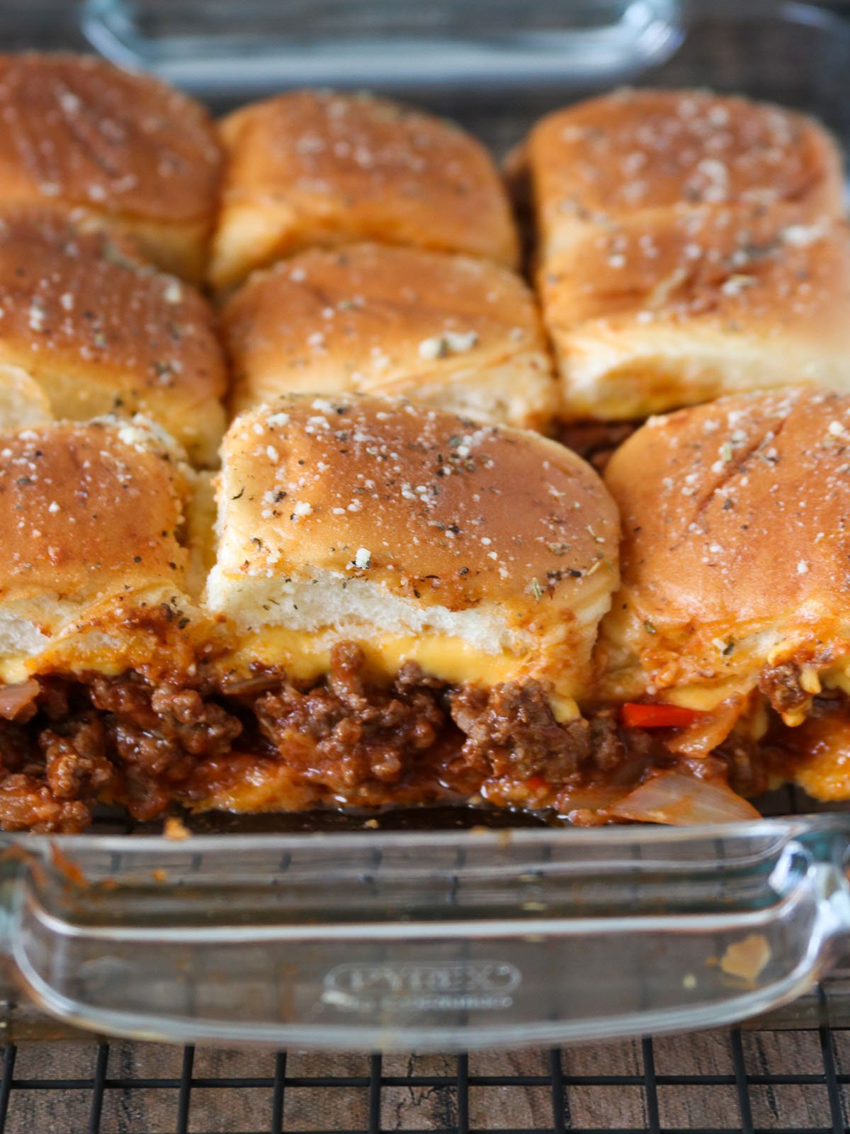 cheesy sloppy joe sliders baked in a glass casserole dish