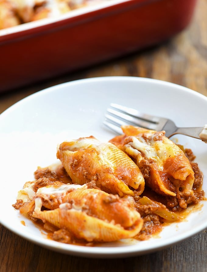 Jumbo pasta shells with ricotta filling and meat sauce on a serving plate