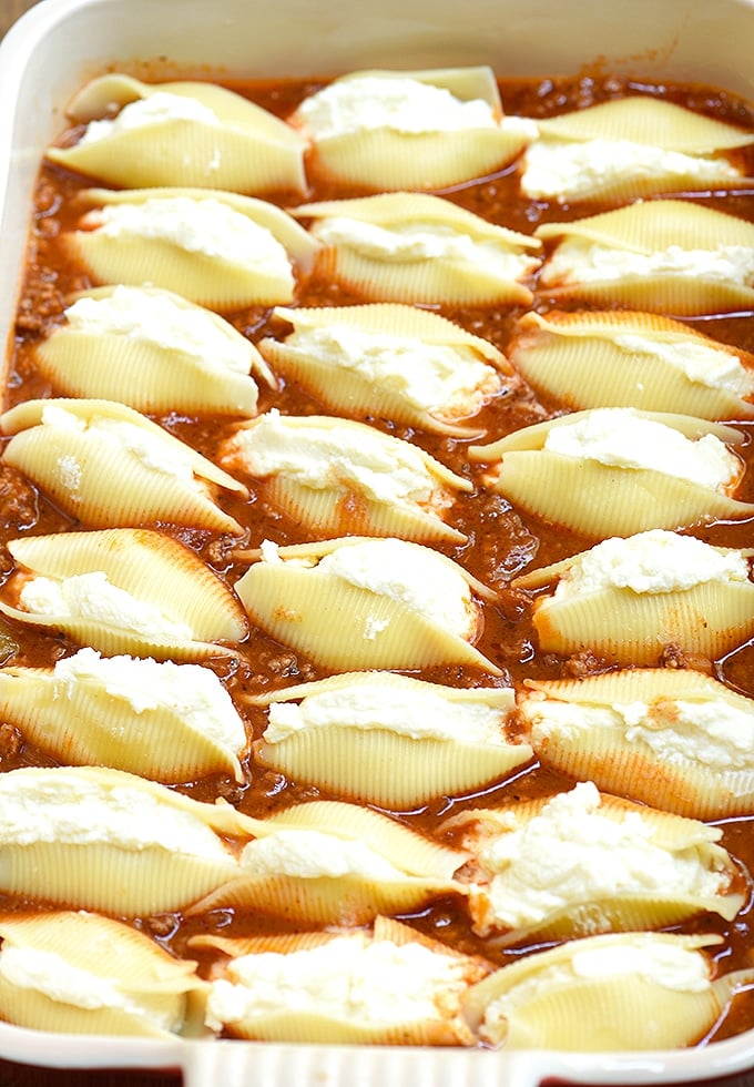 Jumbo pasta shells stuffed with ricotta cheese and layered on meat sauce in a casserole dish