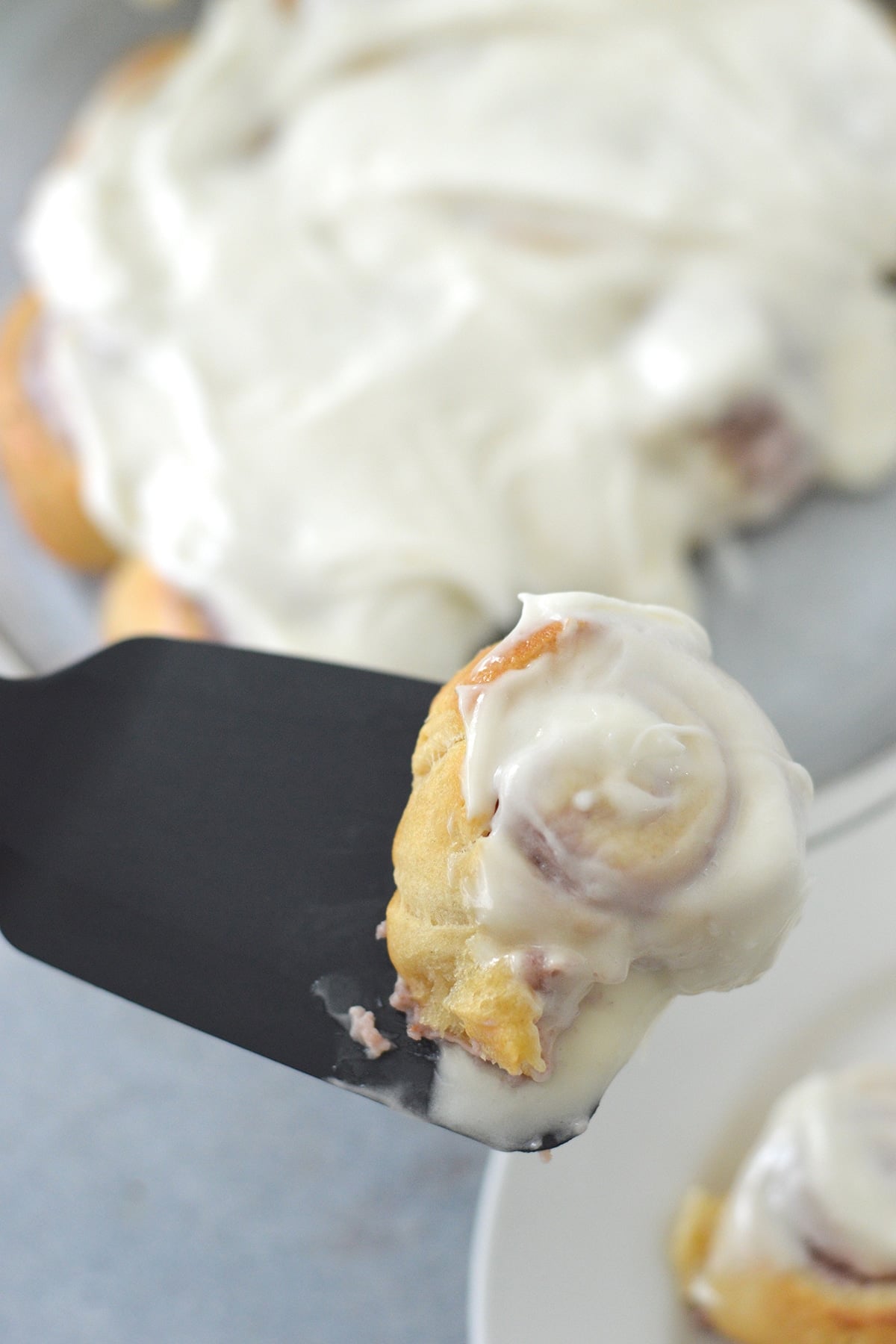 serving cheese danish with cream cheese frosting on a spatula