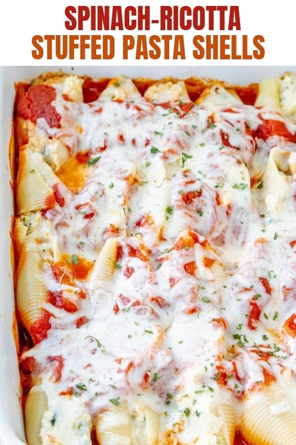 Spinach and Ricotta Stuffed Jumbo Shells baked in a white casserole dish