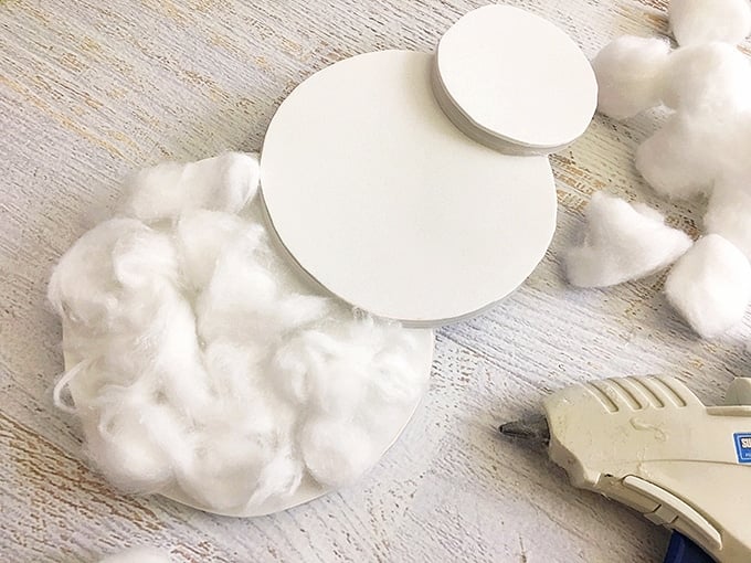 cotton balls glued on snowman-shaped white foam board
