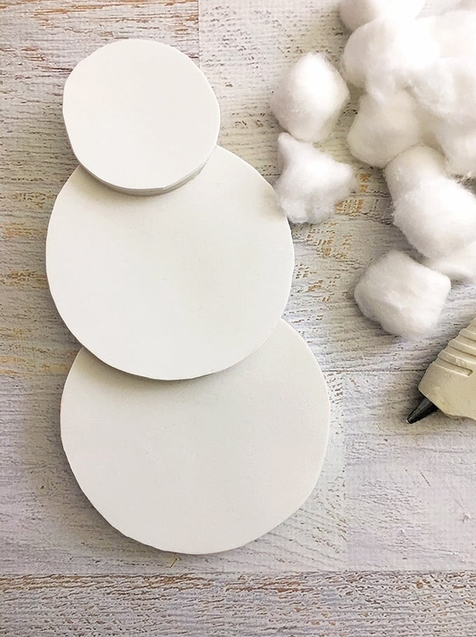 glue together three foam board circles to resemble a snowman shape