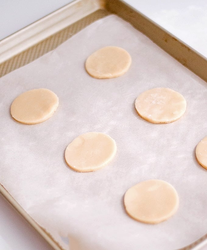 sugar cookie dough circles on a baking sheet