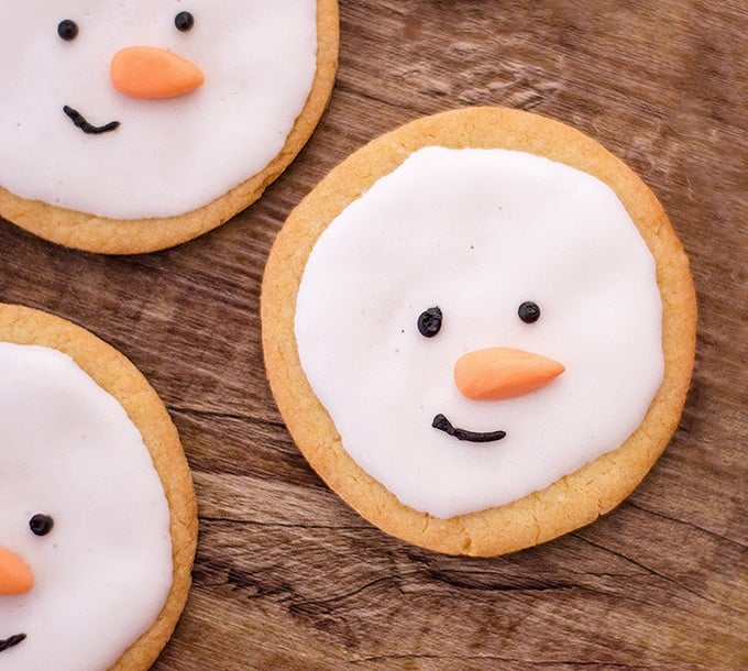 snowman sugar cookies on a wooden board