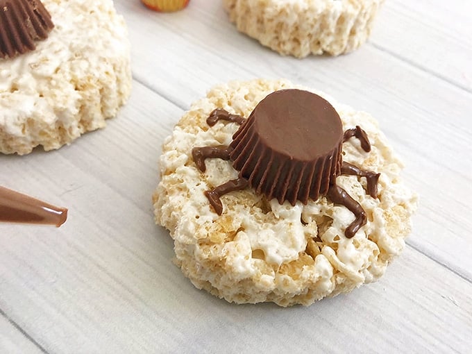 peanut butter cup with chocolate "legs" on round rice krispies treats to resemble spooky spider