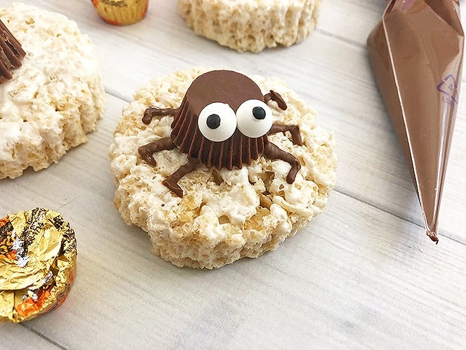 round rice krispies treats decorated with peanut butter cup spiders