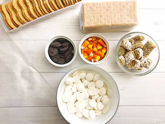 Nutter butters, candy corn, graham crackers, white candy melts, cocoa candy melts, frosted mini-wheats on a white board