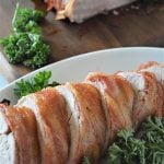 sliced Brown Sugar Bacon-Wrapped Pork Tenderloin on a platter