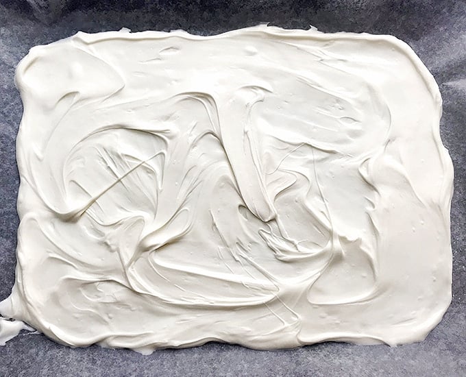 melted white chocolate spread on baking sheet to make candy bark