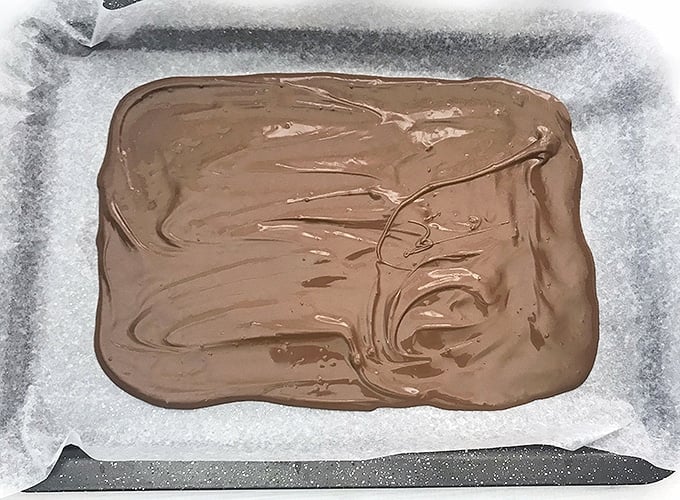 melted chocolate spread thin on parchment lined baking sheet