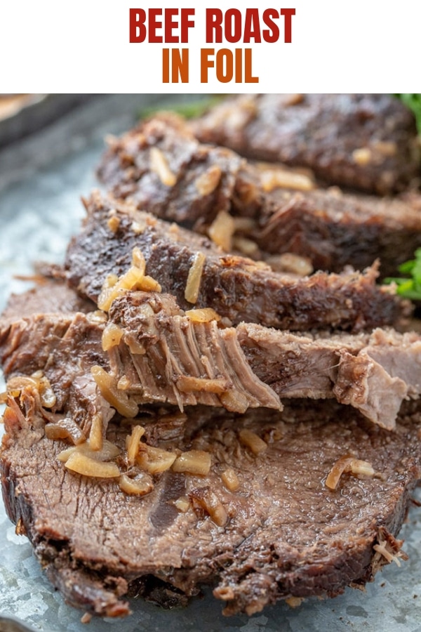 sliced beef roast in foil on a serving platter