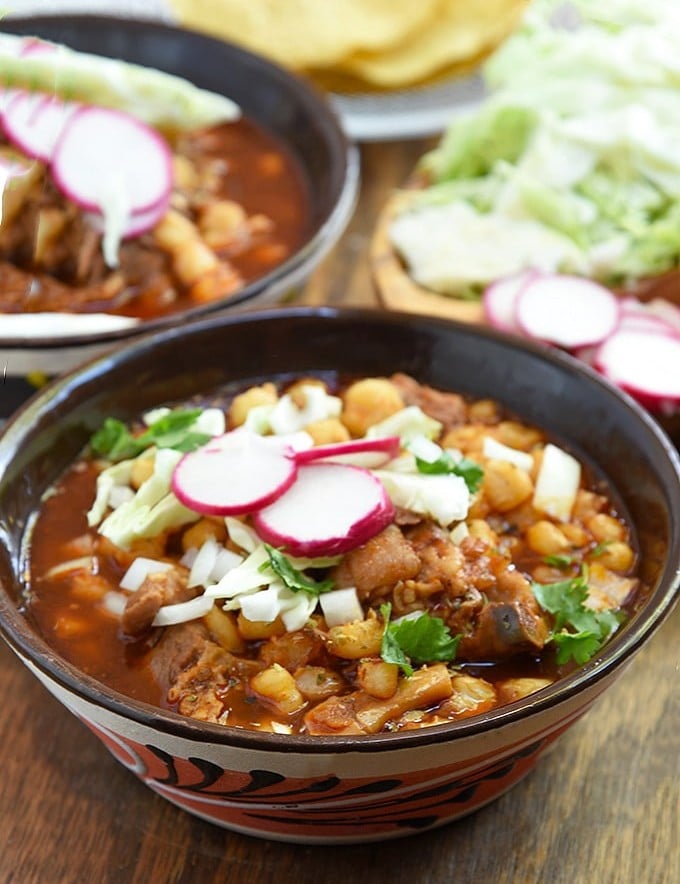 Pork Pozole Rojo with radish, cabbage,and onions in a bowl
