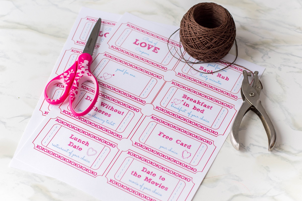 Valentine's day coupon sheet, scissors, puncher, twine