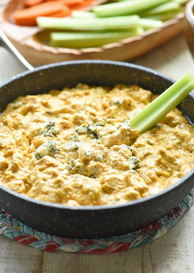 buffalo dip with celery in a cast-iron skillet