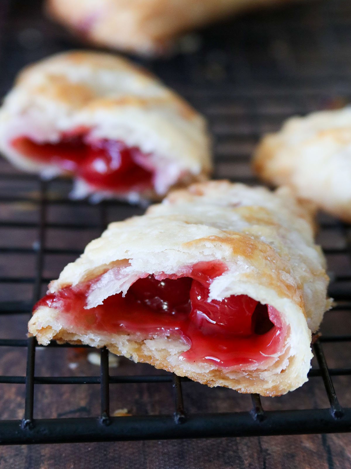 hand pies with cherry pie filling on a black wire rack