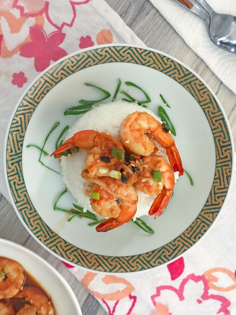 honey soy shrimp stir-fry over steamed rice on a plate