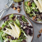 pear salad with dried cranberries, feta cheese and poppy seed dressing on a serving plate