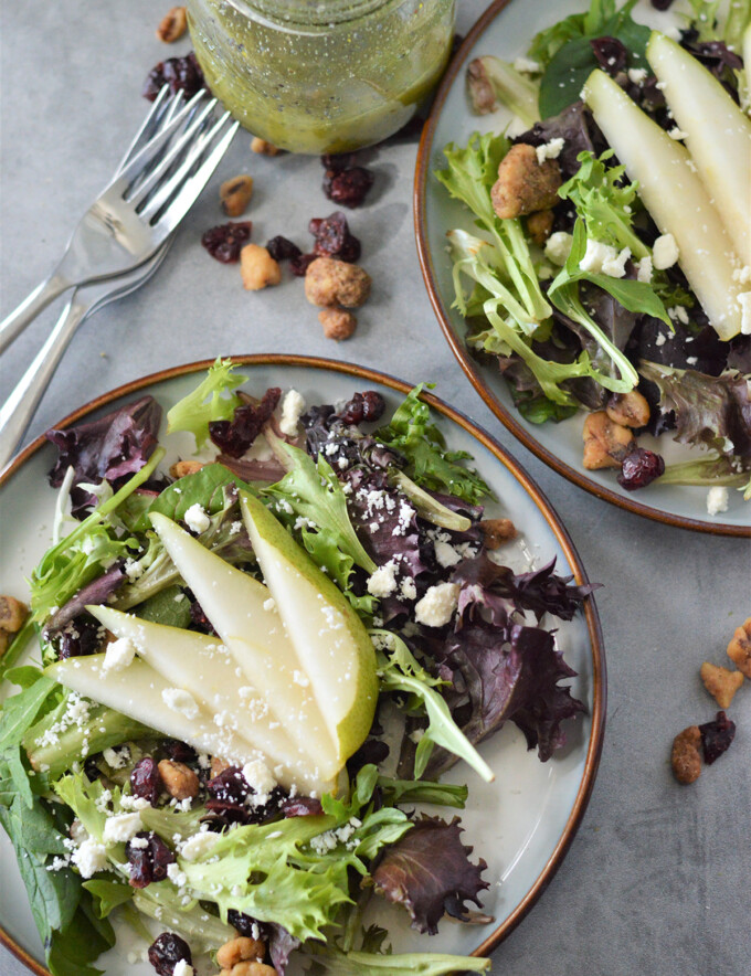 pear salad with dried cranberries, feta cheese and poppy seed dressing on a serving plate