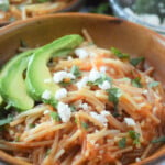 Sopa Seca de Fideo with avocadoes and crumbled cheese in a wooden bowl