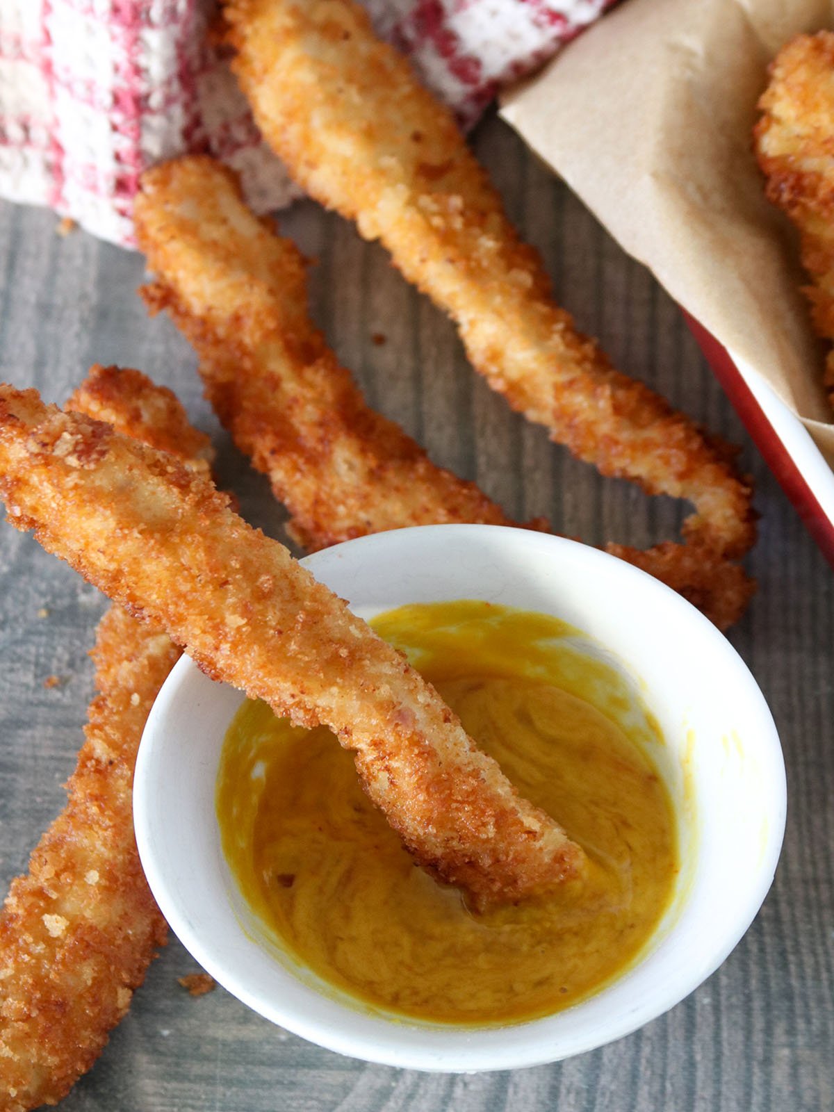 dipping breaded chicken strips in sauce