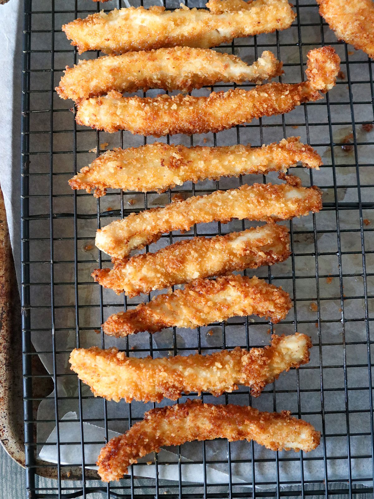 fried breaded chicken fries on a wire rack