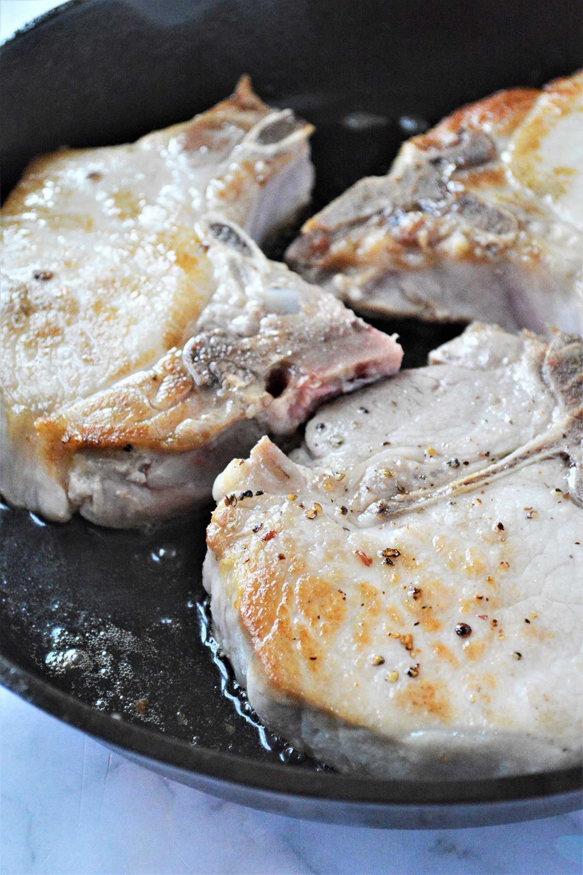frying pork chops in a cast iron skillet