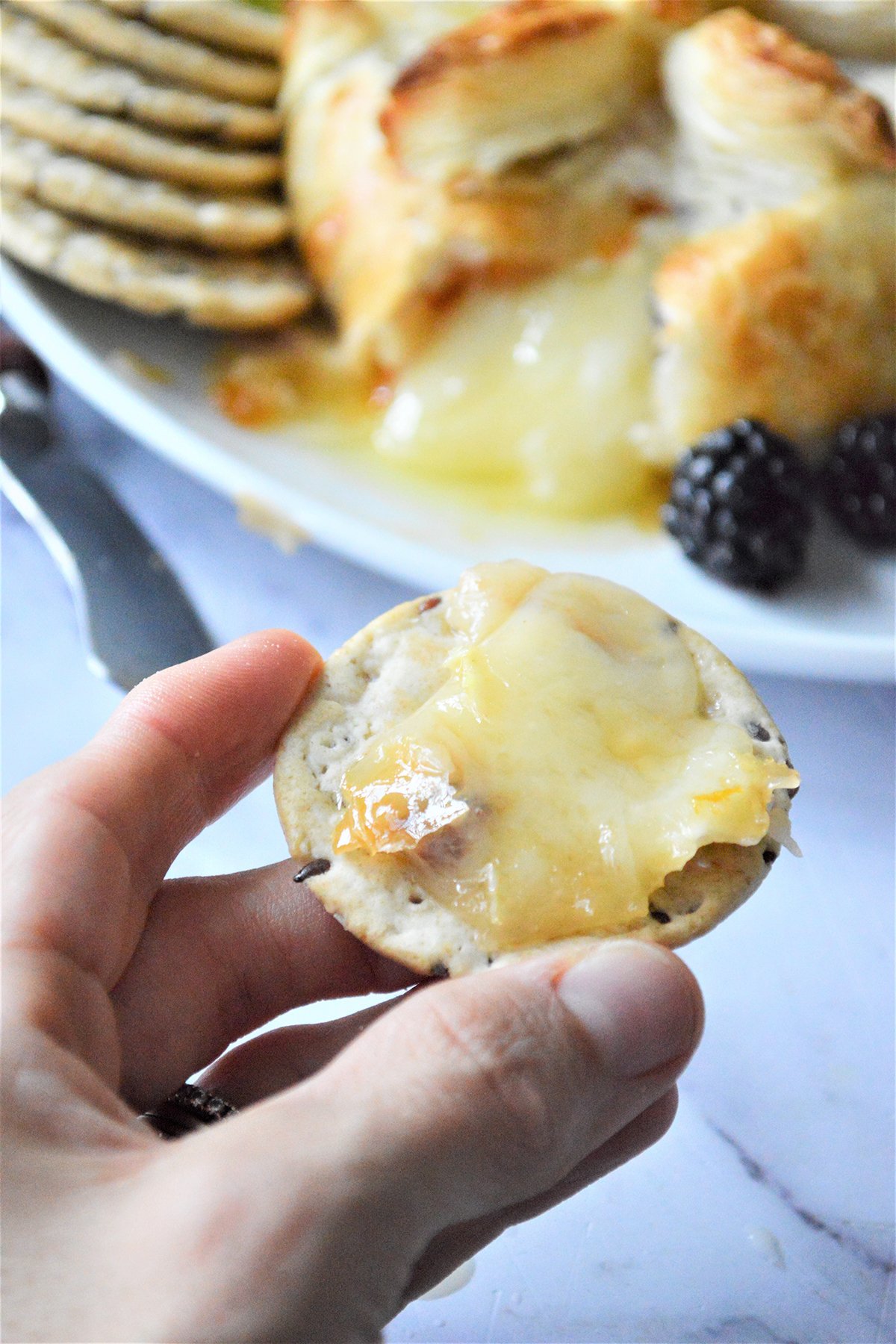 melted baked brie on a cracker