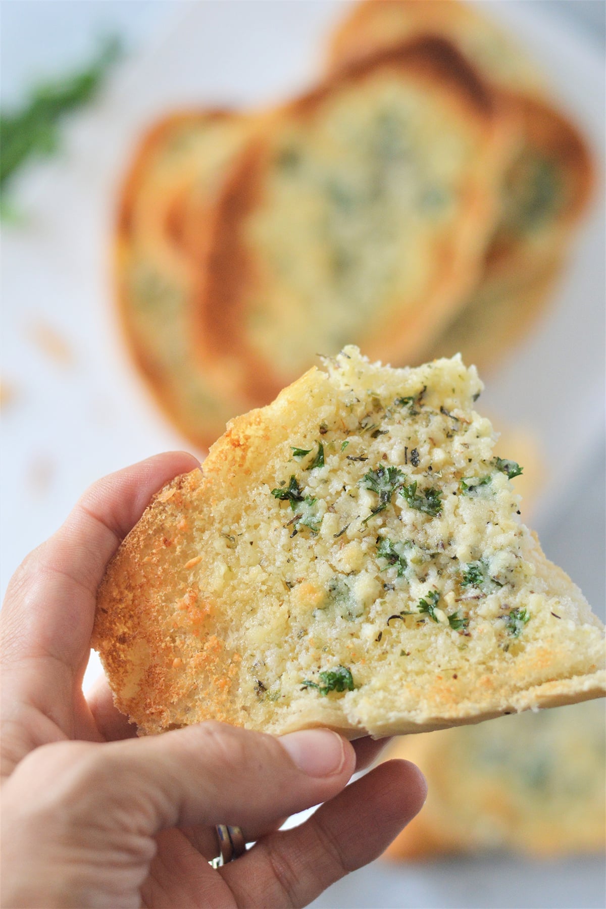 holding a piece of garlic bread.