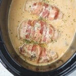 bacon-wrapped chicken cooked in mushroom sauce sauce in a slow cooker.