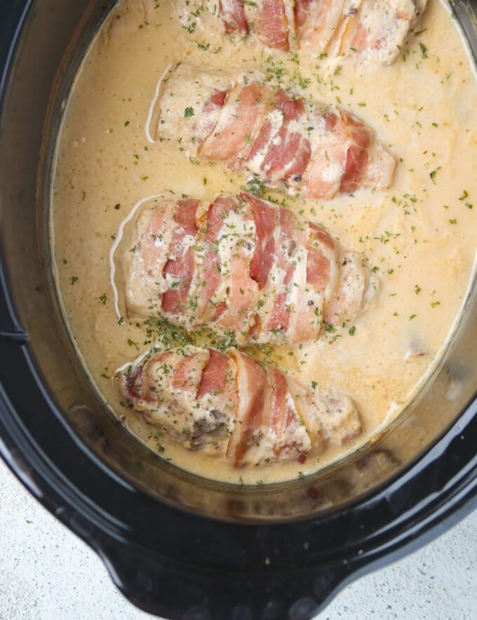 bacon-wrapped chicken cooked in mushroom sauce sauce in a slow cooker.